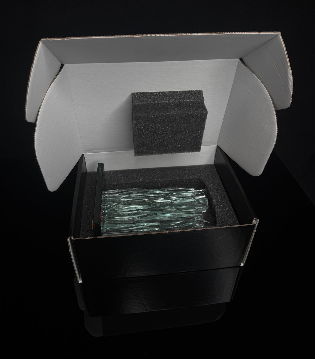 6 inch tall Canadian handcrafted Kiln Formed casted Clear Glass waterfall award statue, that sits on top of a black glass base the award sits inside of a black and white gift box with foam surrounding the award in front of a black studio background