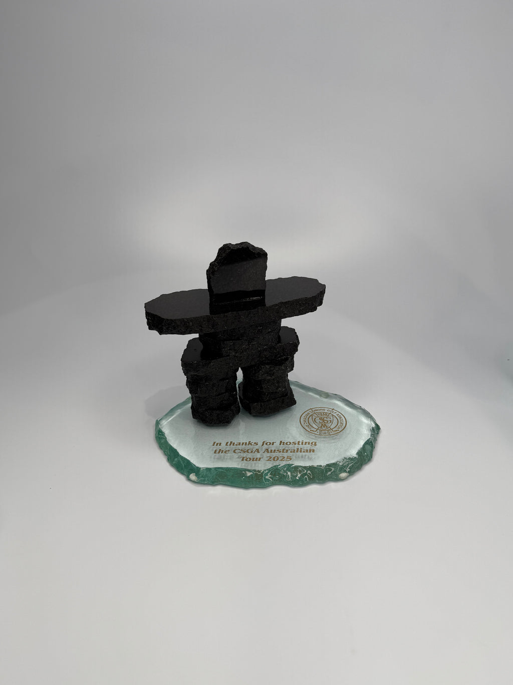 4.5" Black Granite Inukshuk on a Clear glass base with gold etching. infront of a white background