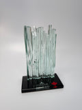 Glass Waterfall sculpture on a black base with 'Champions' and a maple leaf logo on a gray background