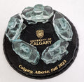 5 Clear Glass Handcrafted Inukshuks, standing in a circle, on top of a glass base that is painted black with gold etching stating "University of Calgary Calgary, Alberta, fall 2023"