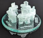 5 Frosted glass inukshuks standing in a friendship circle. on top of a glass base with logos engraved behind each inukshuk