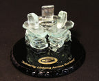 3 Handcrafted clear glass inukshuks on top of a glass base that is painted black with gold etching on top